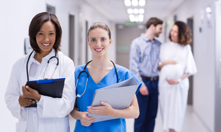 Medical staff and pregnant couple in hospital