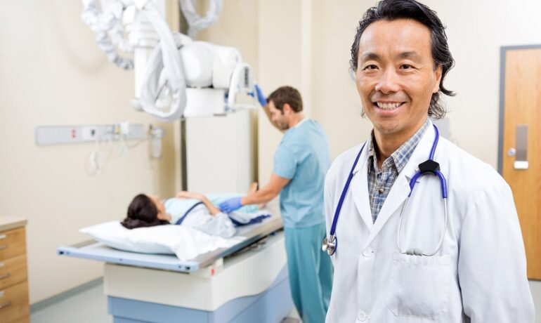 Smiling doctor in radiology room with patient