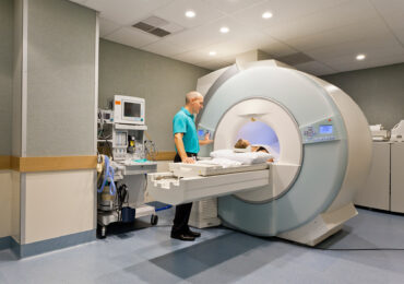 Medical technician preparing patient for MRI scan