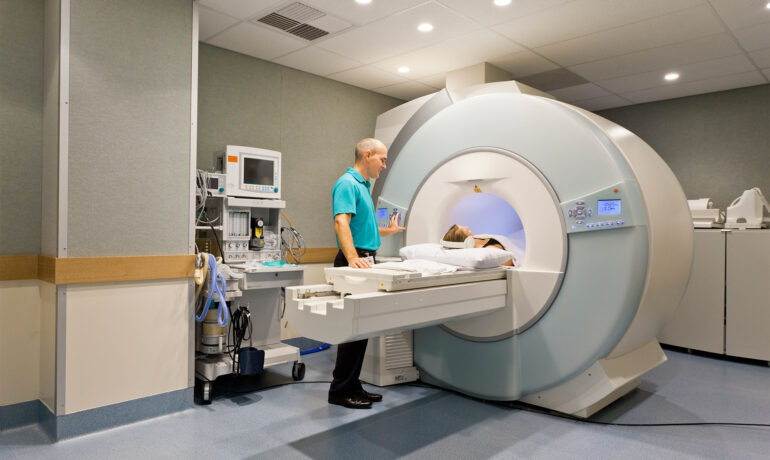 Medical technician preparing patient for MRI scan