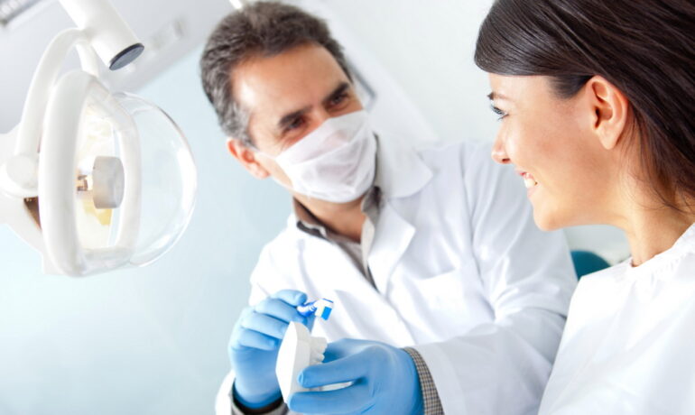 Dentist explaining dental device to smiling patient