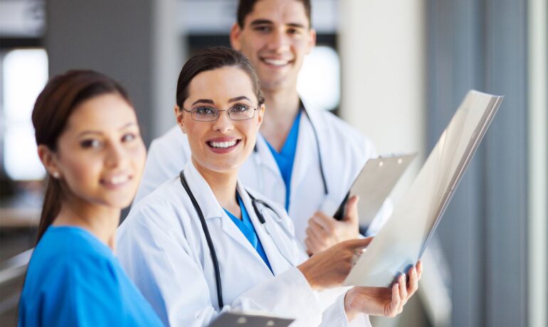Smiling medical team reviewing patient charts