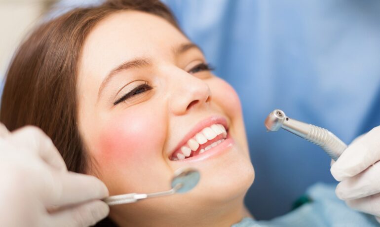 Woman smiling during dental checkup with instruments